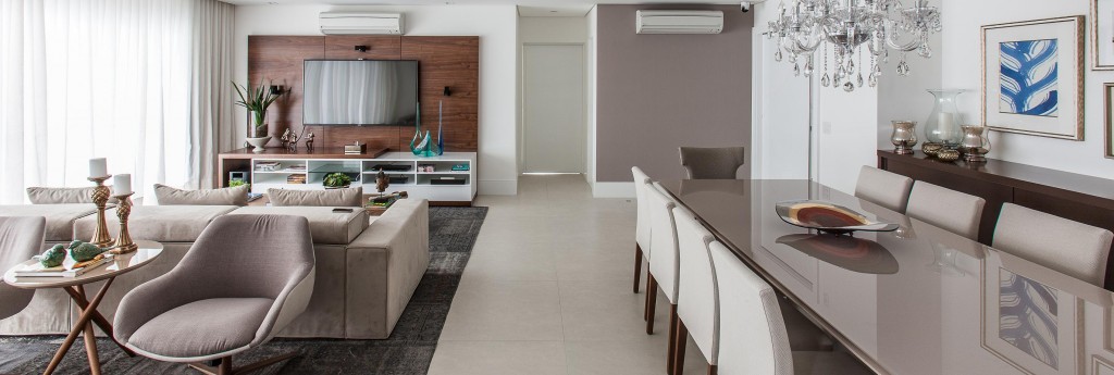 O living abriga estar, home theater e jantar, e se integra à varanda gourmet quando as portas de correr estão abertas.